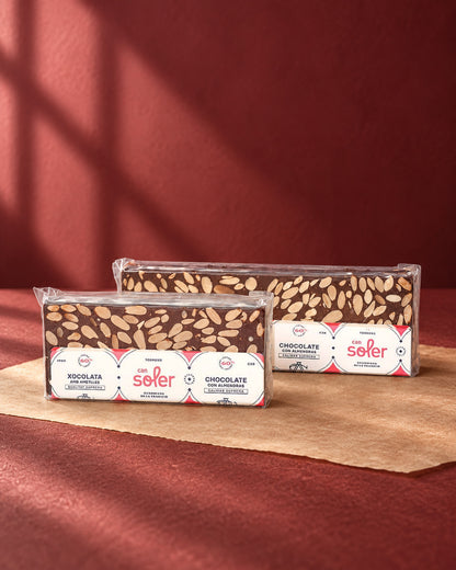 Dos tamaños de turrón de chocolate 60 % con almendras de Can Soler en envase transparente con etiqueta bilingüe