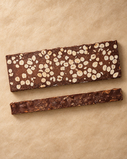 Vista desde arriba del turrón de chocolate 60 % con avellanas de Can Soler, con la barra entera y una loncha lateral