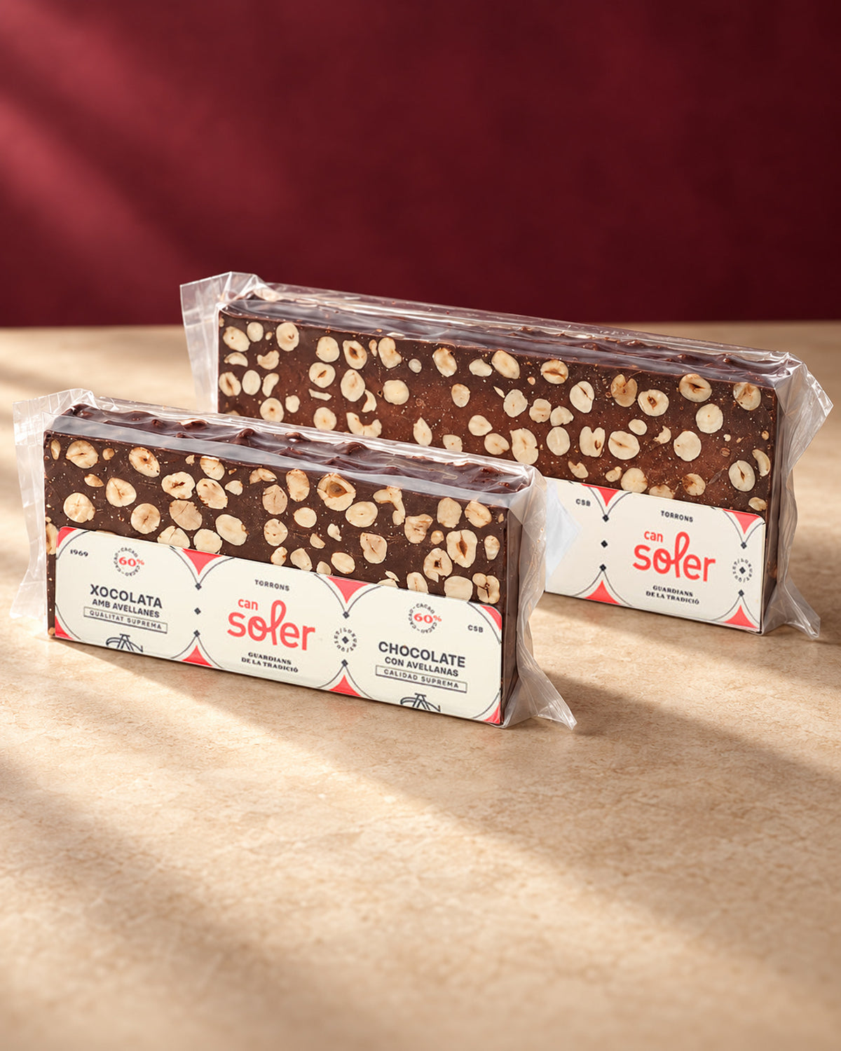 Dos turrones de chocolate 60 % con avellanas de Can Soler en su envase transparente con la etiqueta de la marca