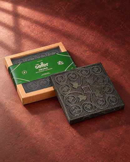Chocolate de Museo «L'Heura» de Can Soler: placa con relieve de hojas de hiedra y espirales junto a su estuche con faja verde
