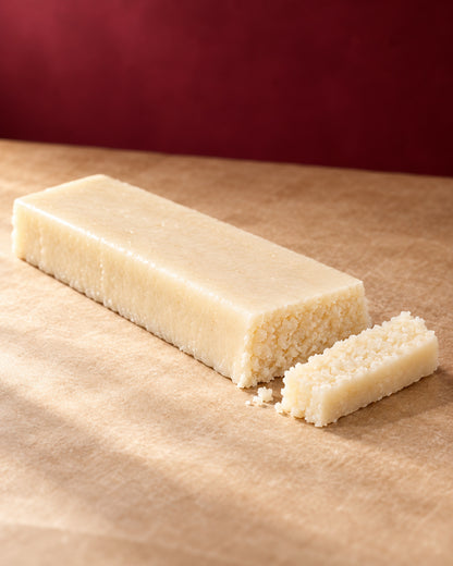 Barra de turrón de coco de Can Soler con una porción cortada al lado que deja ver su interior de coco rallado