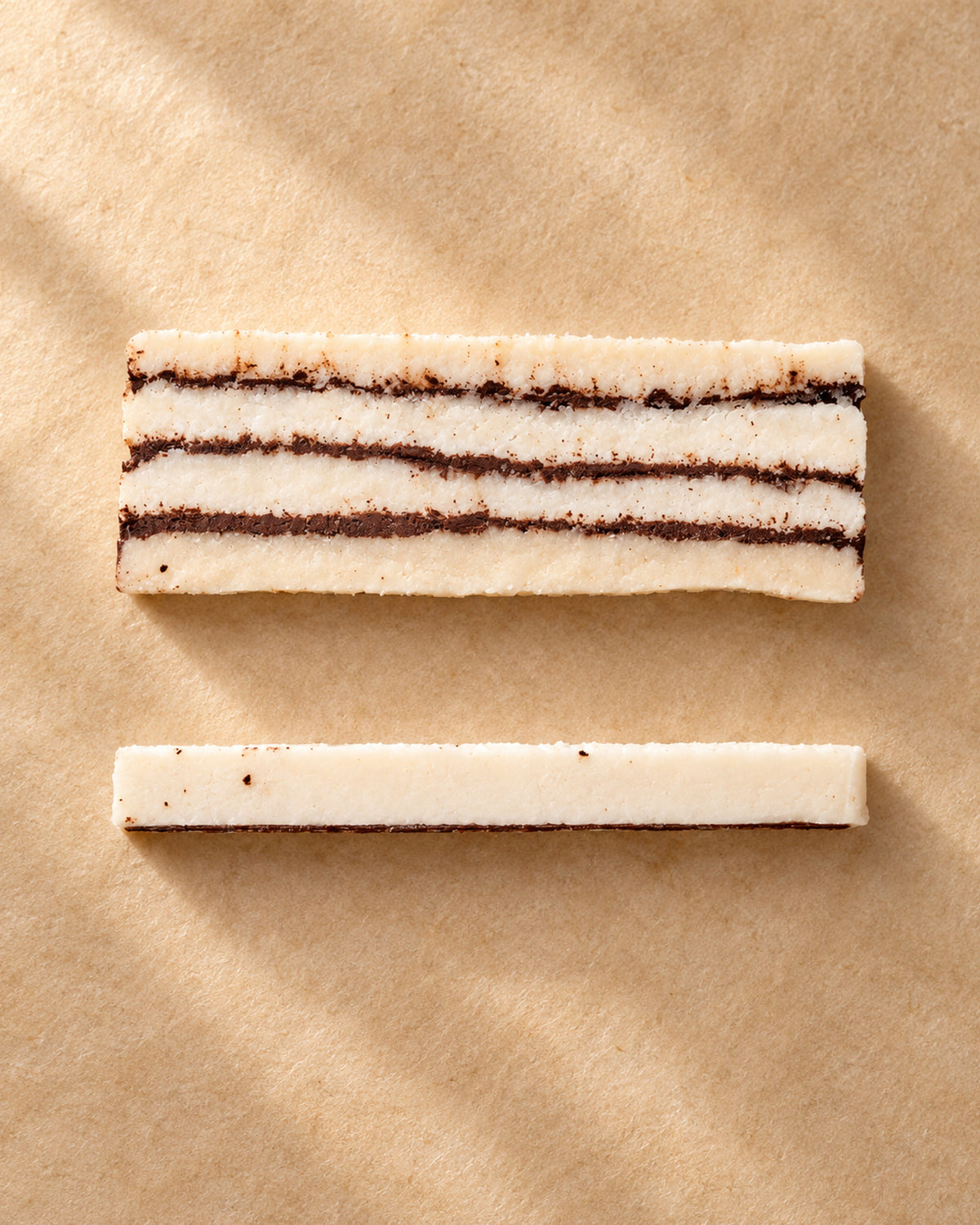 Vista desde arriba de una pieza de turrón de coco con chocolate de Can Soler, en capas, y una loncha lateral