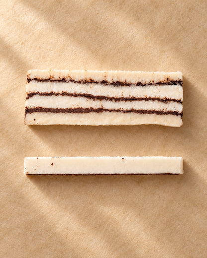 Vista desde arriba de una pieza de turrón de coco con chocolate de Can Soler, en capas, y una loncha lateral