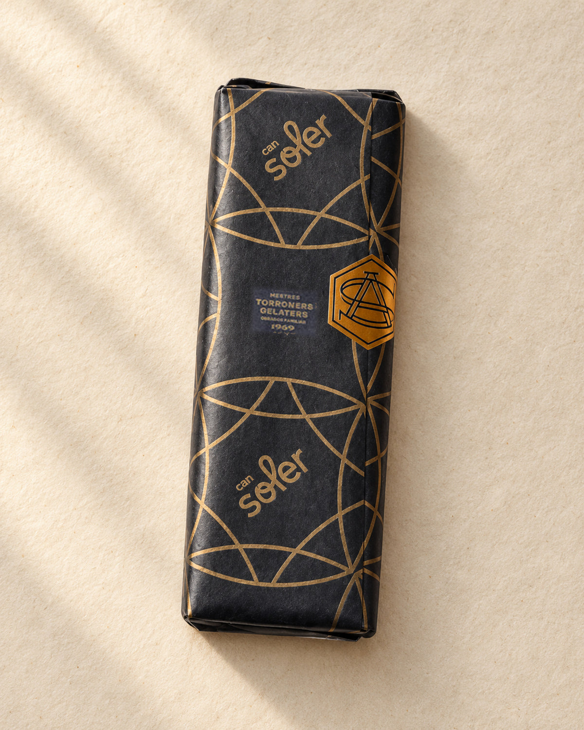 Turrón de coco con chocolate de Can Soler envuelto en papel negro con estampado dorado de la marca
