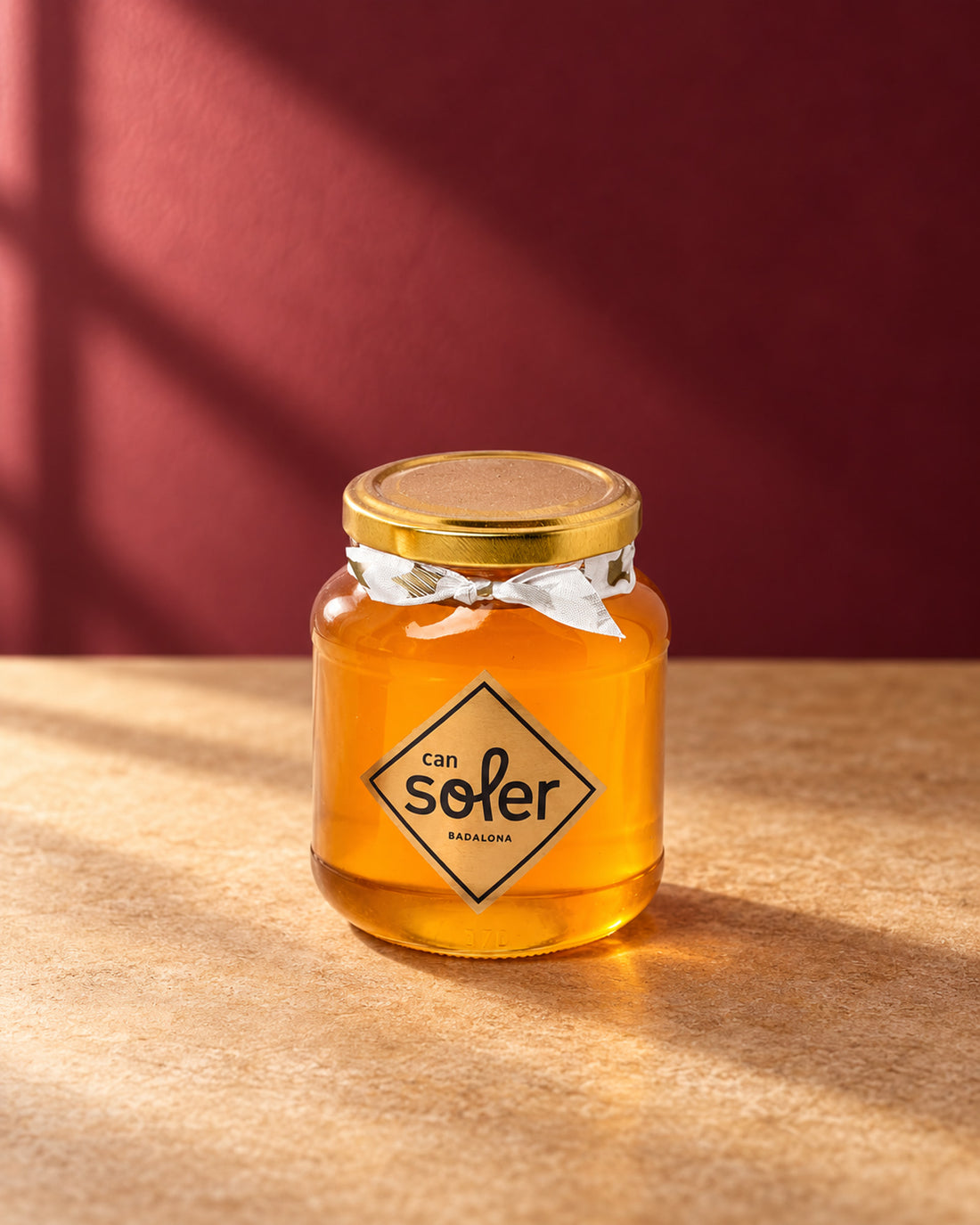 Tarro de cristal de miel natural de azahar Can Soler con tapa dorada, lazo y etiqueta romboidal de la marca