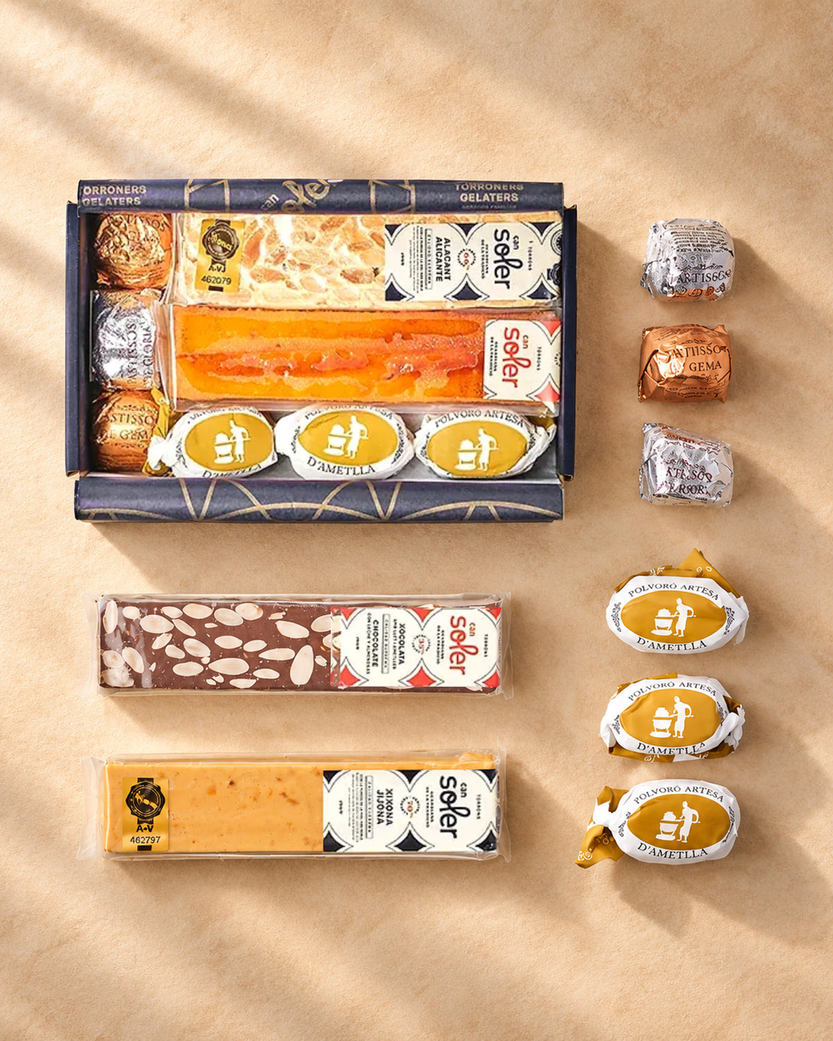 Vista desde arriba del pack degustación «Somos 2 en casa» de Can Soler con su caja y los turrones, pastelitos y polvorones al lado