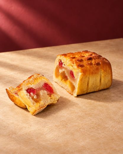 Pan de Cádiz de Can Soler con la superficie tostada y una porción cortada que muestra la fruta confitada