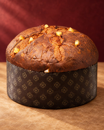Panettone Fiasconaro edición Dolce&Gabbana de manzana y canela entero en su molde de papel, con trozos de manzana en la corteza