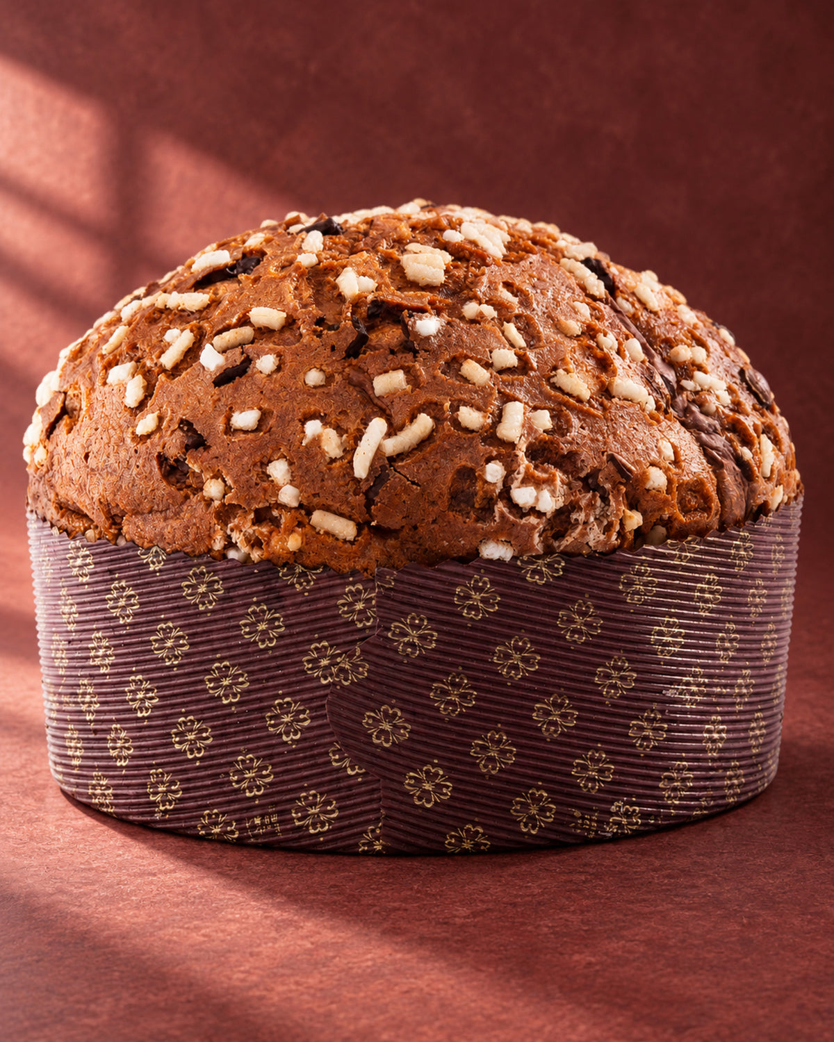 Panettone Fiasconaro de chocolate entero en su molde de papel, con azúcar en grano y pepitas de chocolate por encima