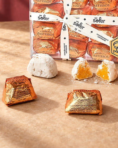 Detalle de los pastelitos de mazapán de yema de Can Soler: piezas envueltas en dorado y una partida con su relleno