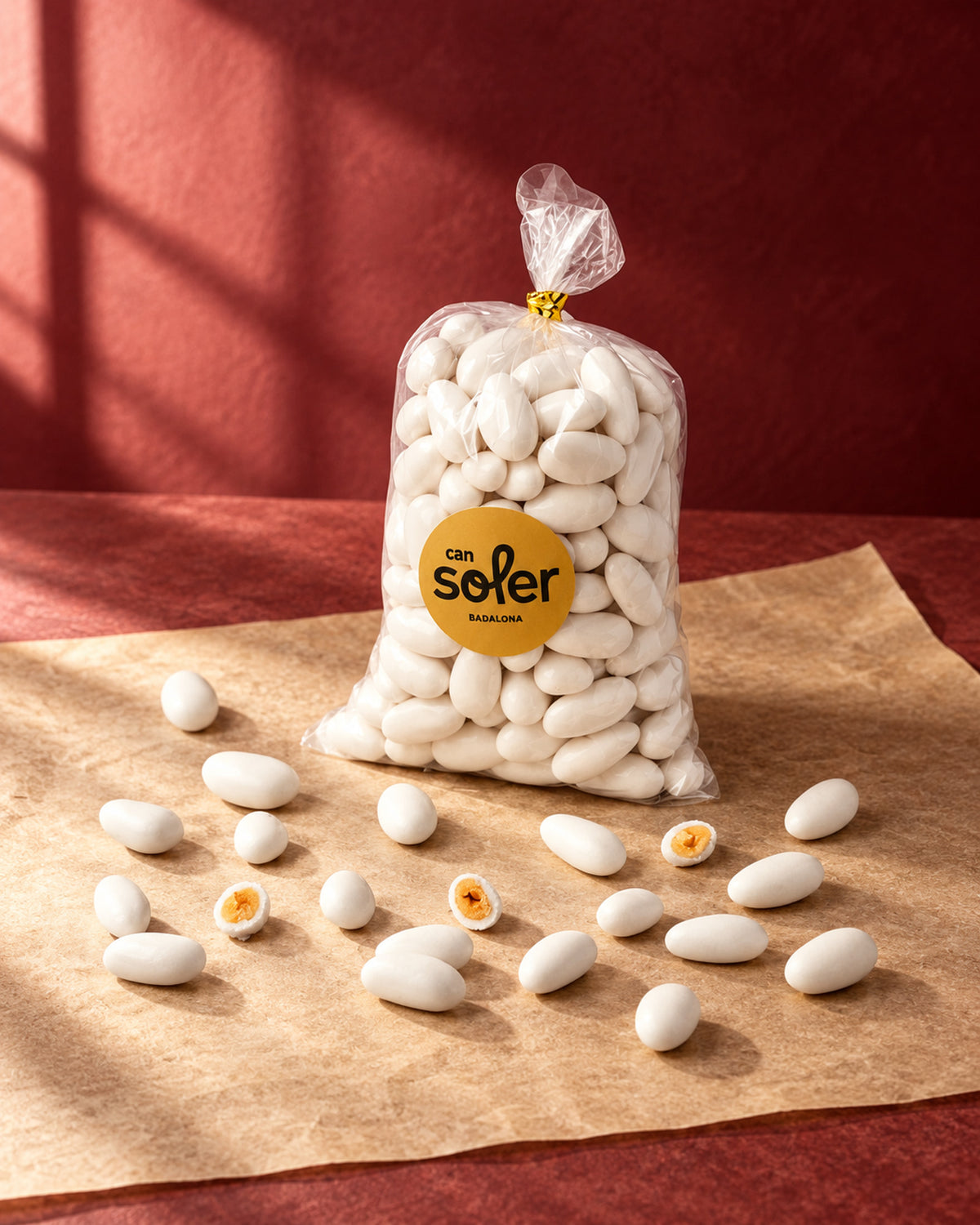 Bolsa transparente de piñones de Can Soler con etiqueta redonda, con confites blancos sueltos y algunos partidos por la mitad