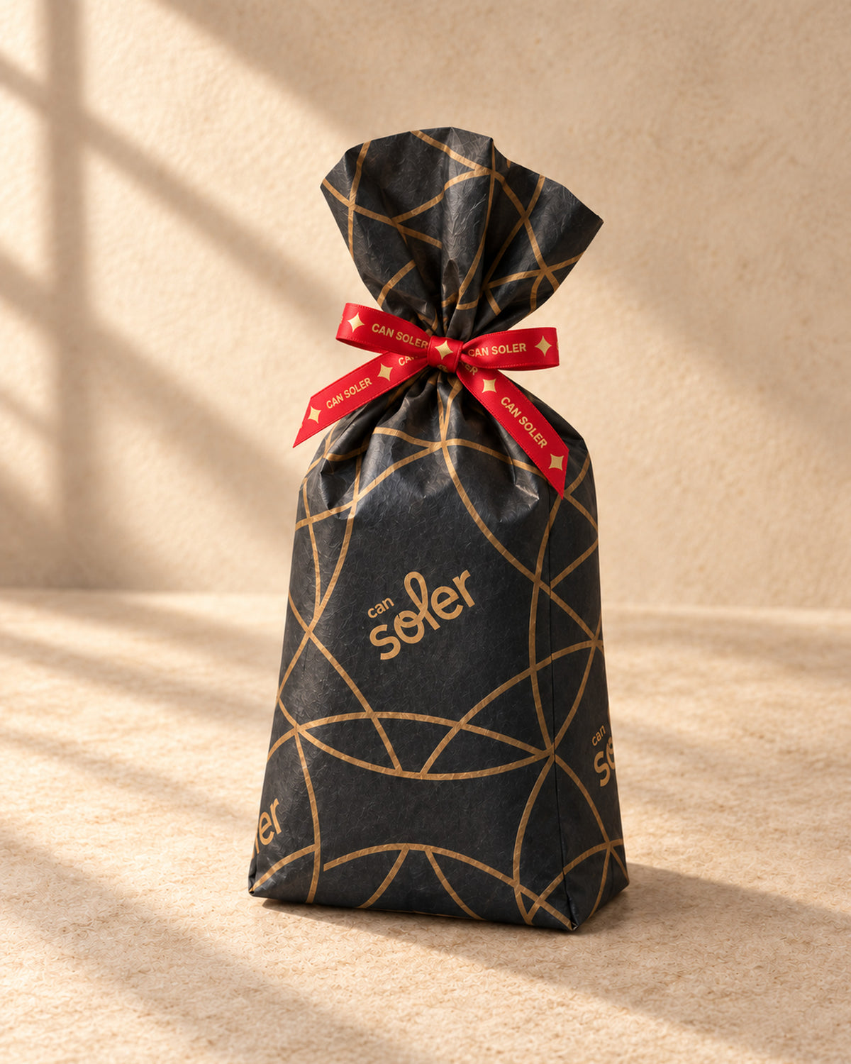 Piñones de Can Soler envueltos para regalo en papel negro con dibujo dorado y cinta roja de la casa
