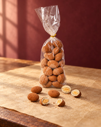 Almendras al cacao de Can Soler en bolsa transparente atada, con almendras sueltas y algunas partidas delante
