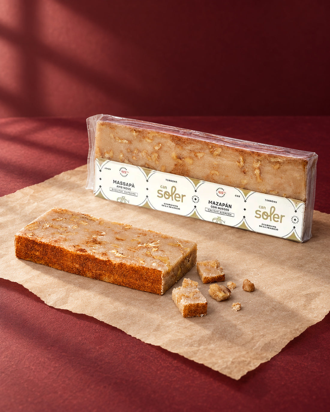 Turrón de mazapán con nueces de Can Soler en su envase junto a una barra tostada y porciones cortadas