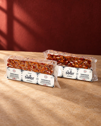 Dos paquetes de turrón «Terronico» de Can Soler con su etiqueta, con almendras caramelizadas y semillas a la vista