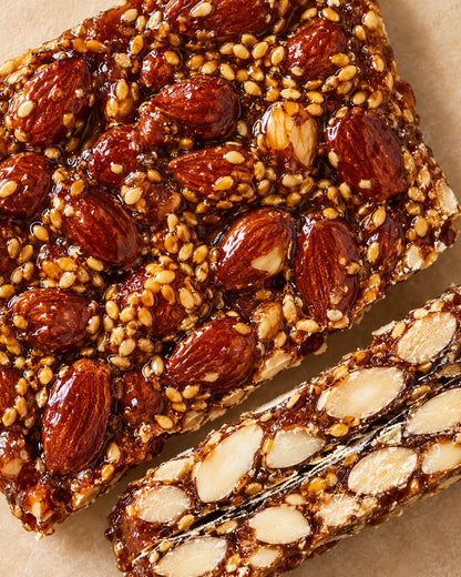 Primer plano de la textura del turrón «Terronico» de Can Soler, con almendras caramelizadas, semillas y un corte lateral